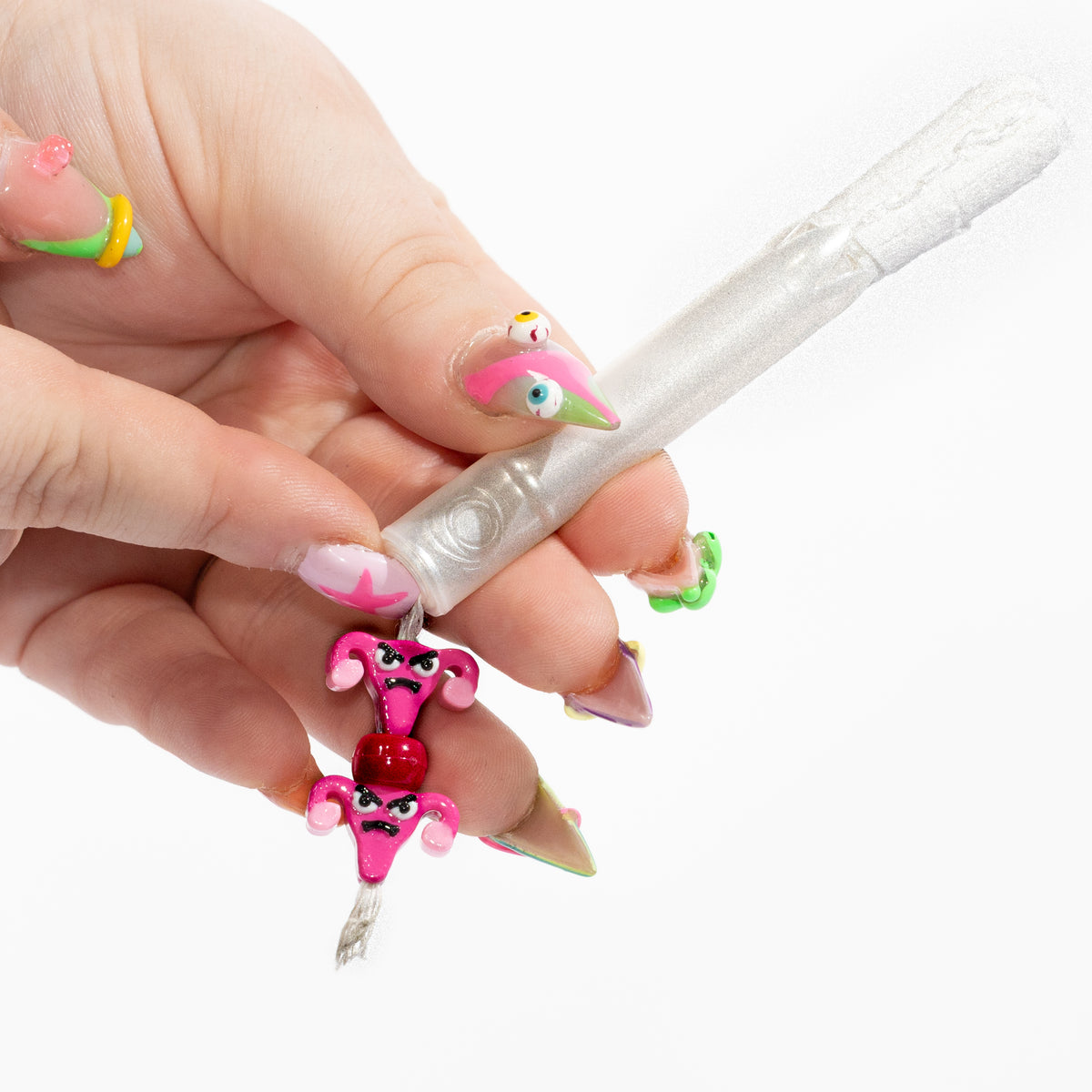 Hand with bright nail art holding a tampon strung with angry pink uterus kandi beads
