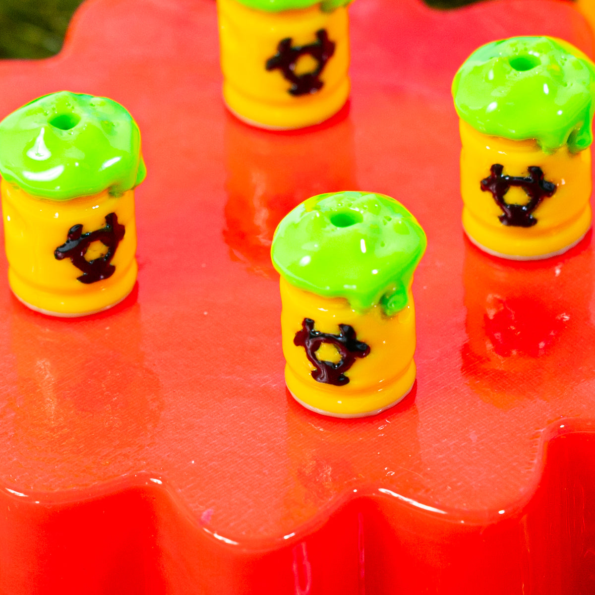 Yellow biohazard barrel kandi beads with oozing green slime, top holes visible