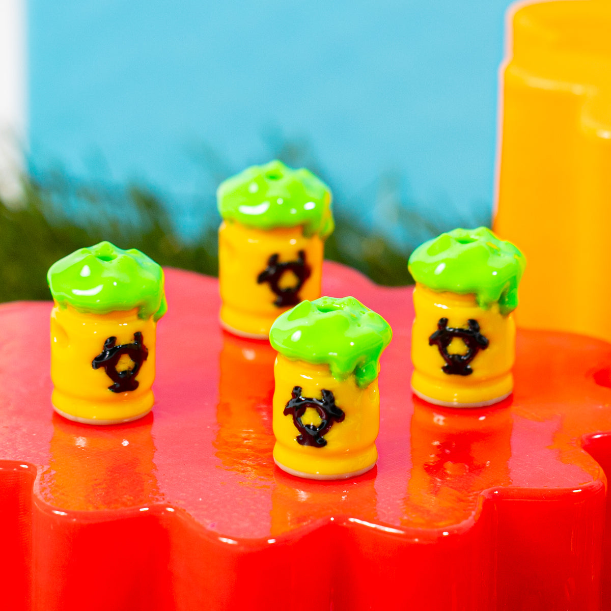 Biohazard barrel kandi beads grouped on a glossy red riser