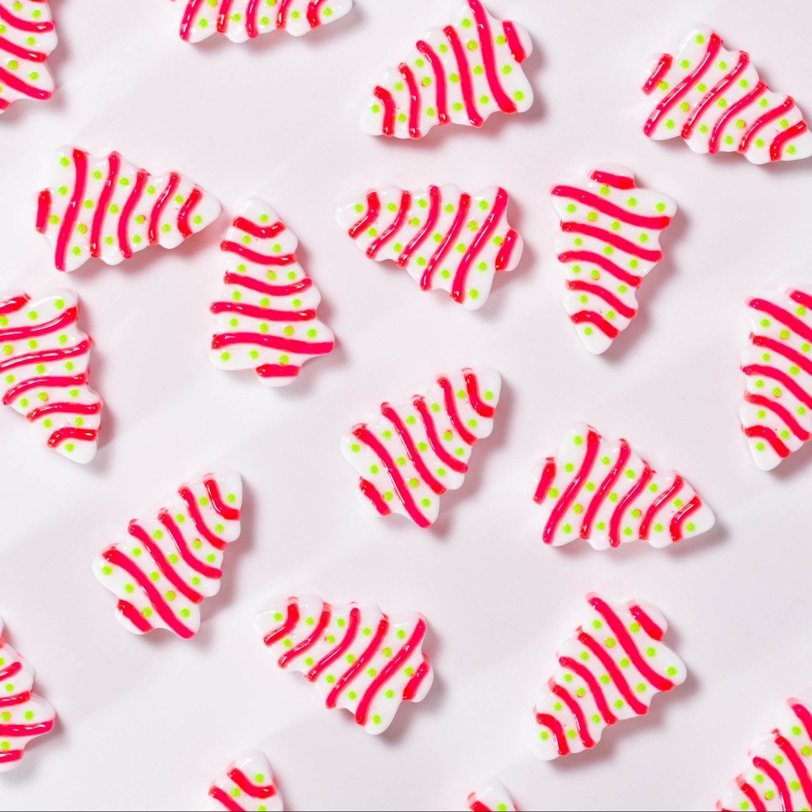 Christmas tree cake kandi beads in tilted rows on white, red icing stripes and green dots