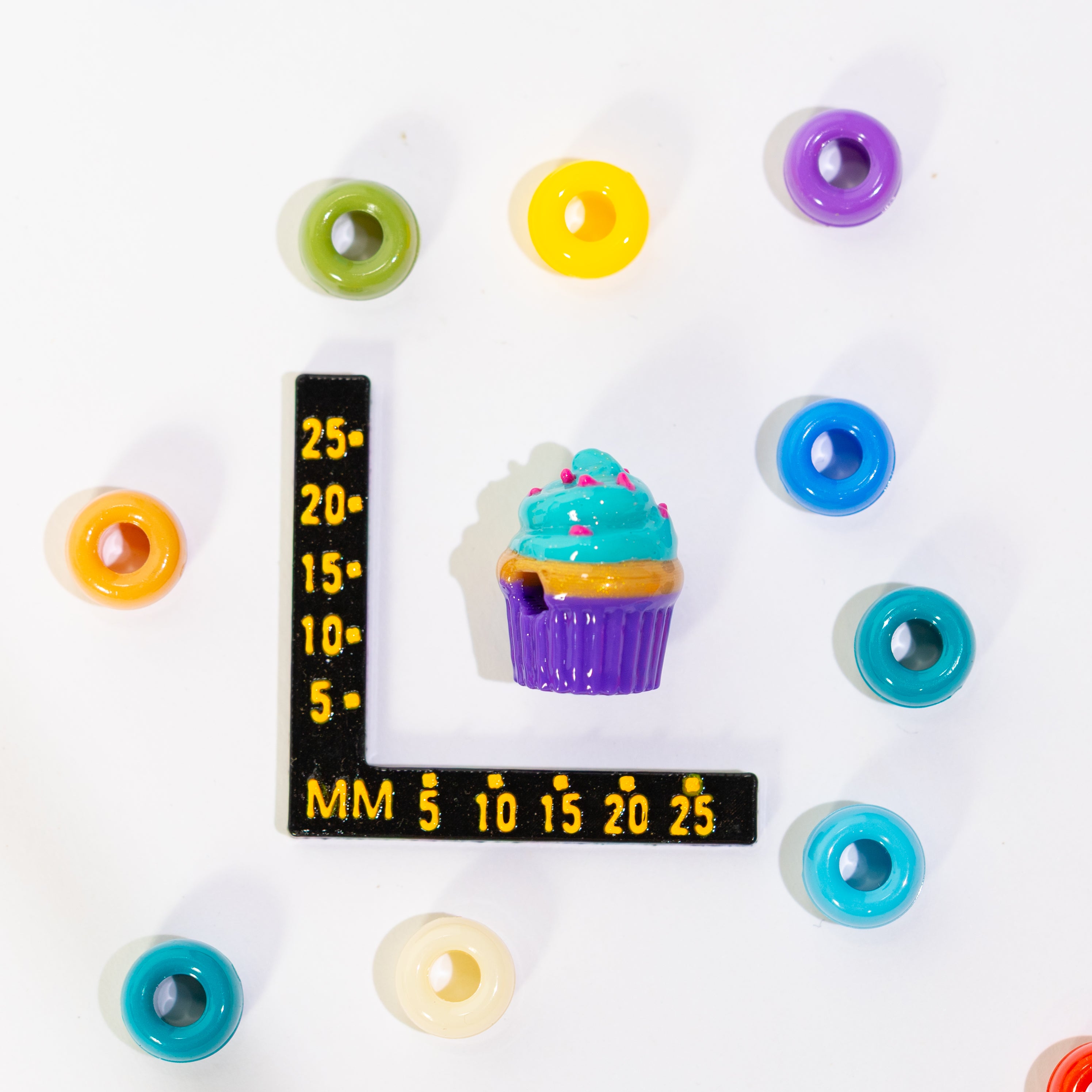 Size guide: a cupcake kandi bead beside a millimeter ruler for scale