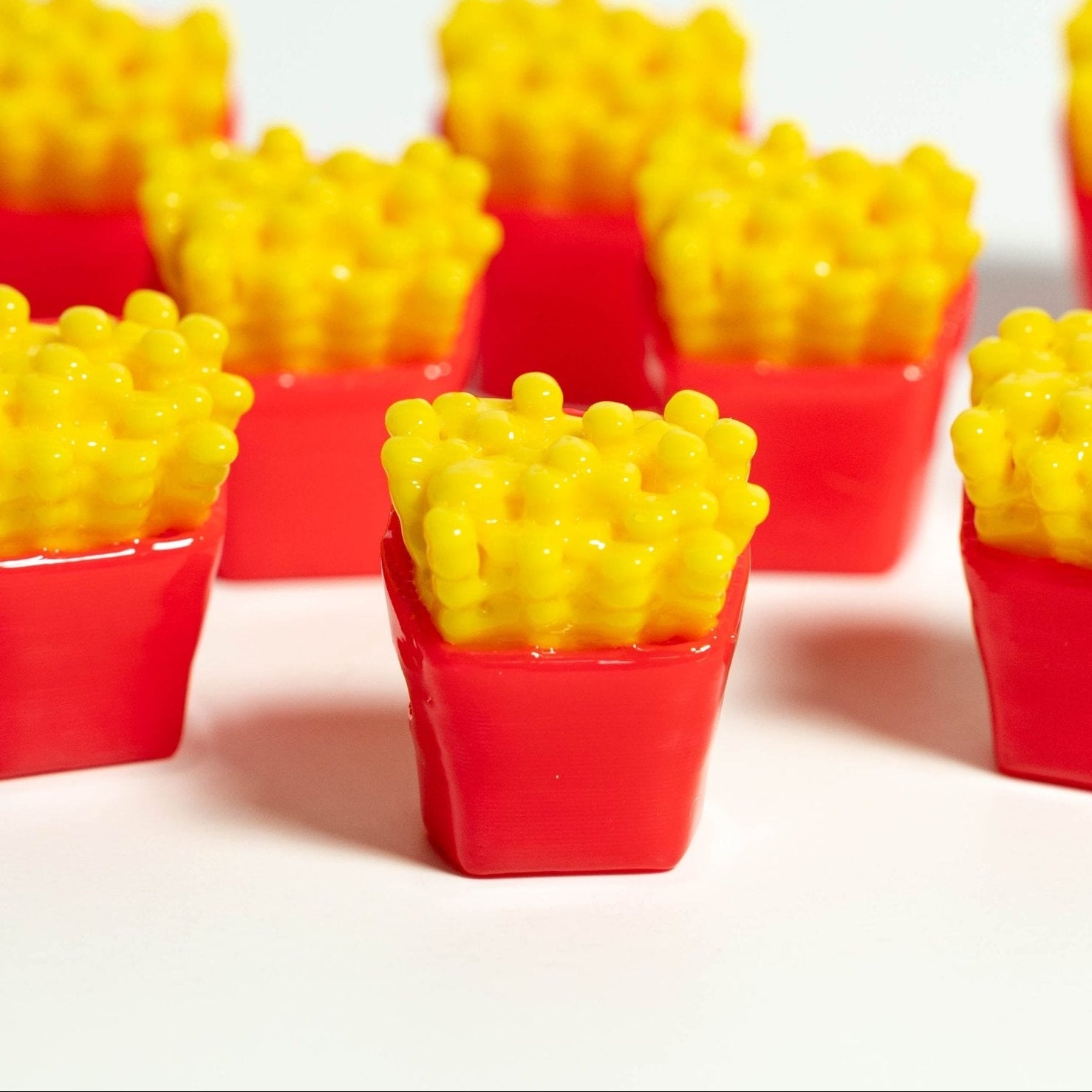 Red and yellow french fry carton beads standing in rows, one sharp in the center