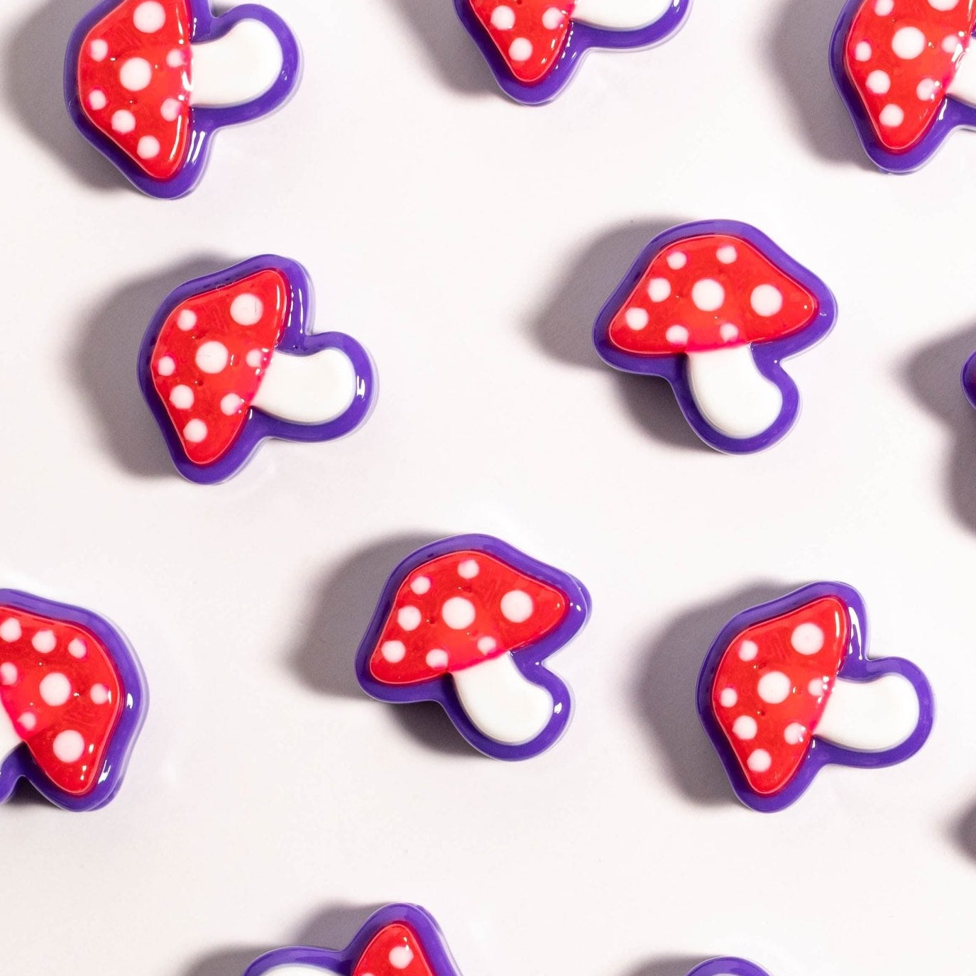 Mushroom kandi beads with red spotted caps in a repeating grid, seen from above