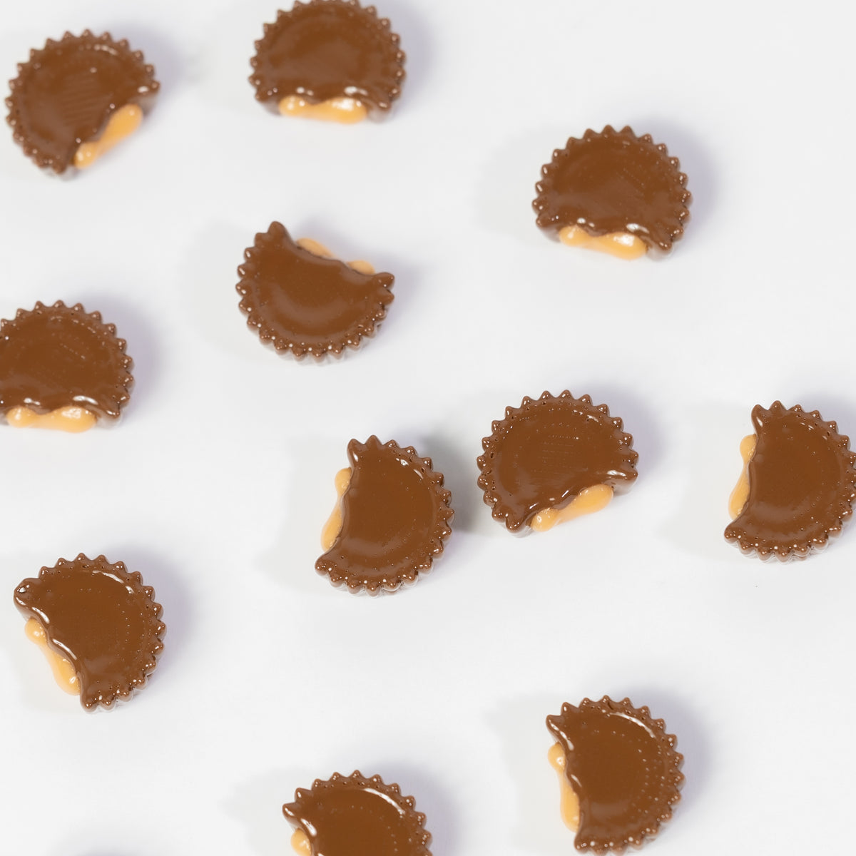 Peanut butter cup kandi beads with a bite missing scattered on white