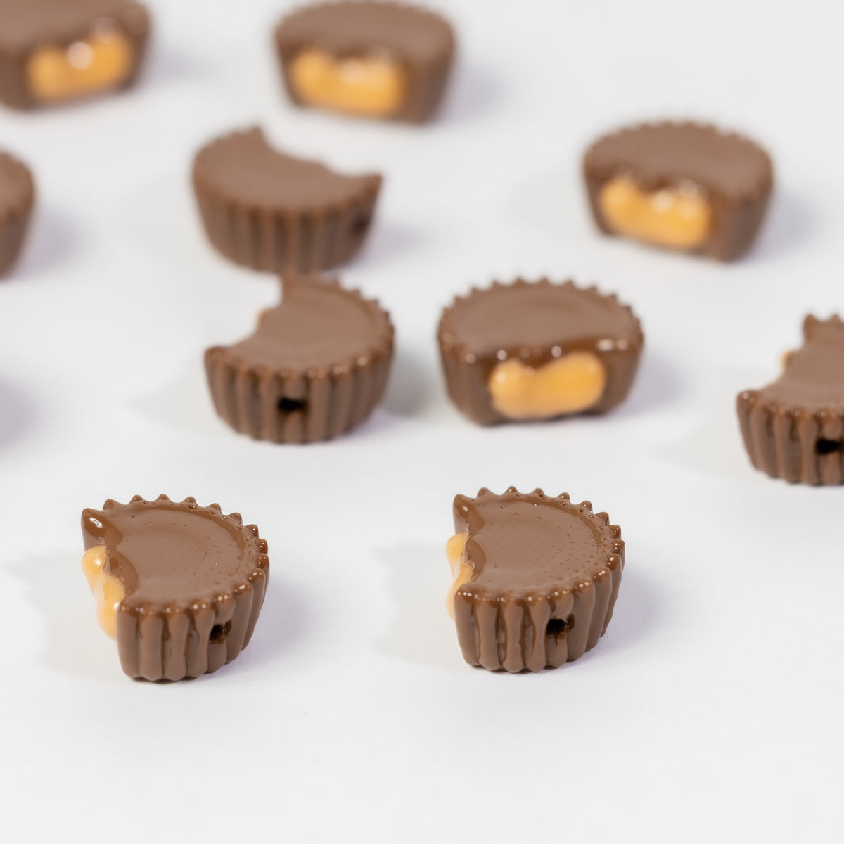 Chocolate peanut butter cup kandi beads on white, drilled holes visible