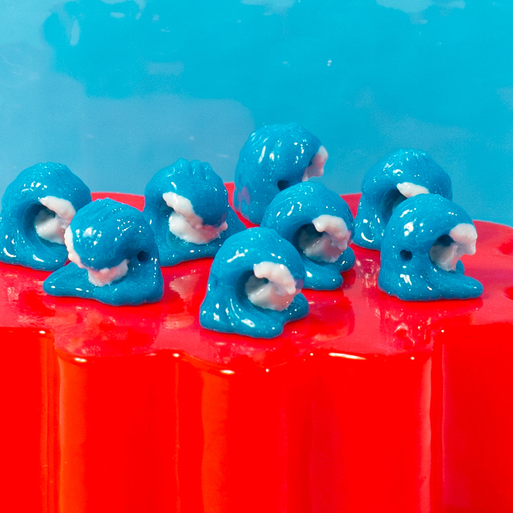 Blue wave kandi beads with white foam crests lined up along a red riser