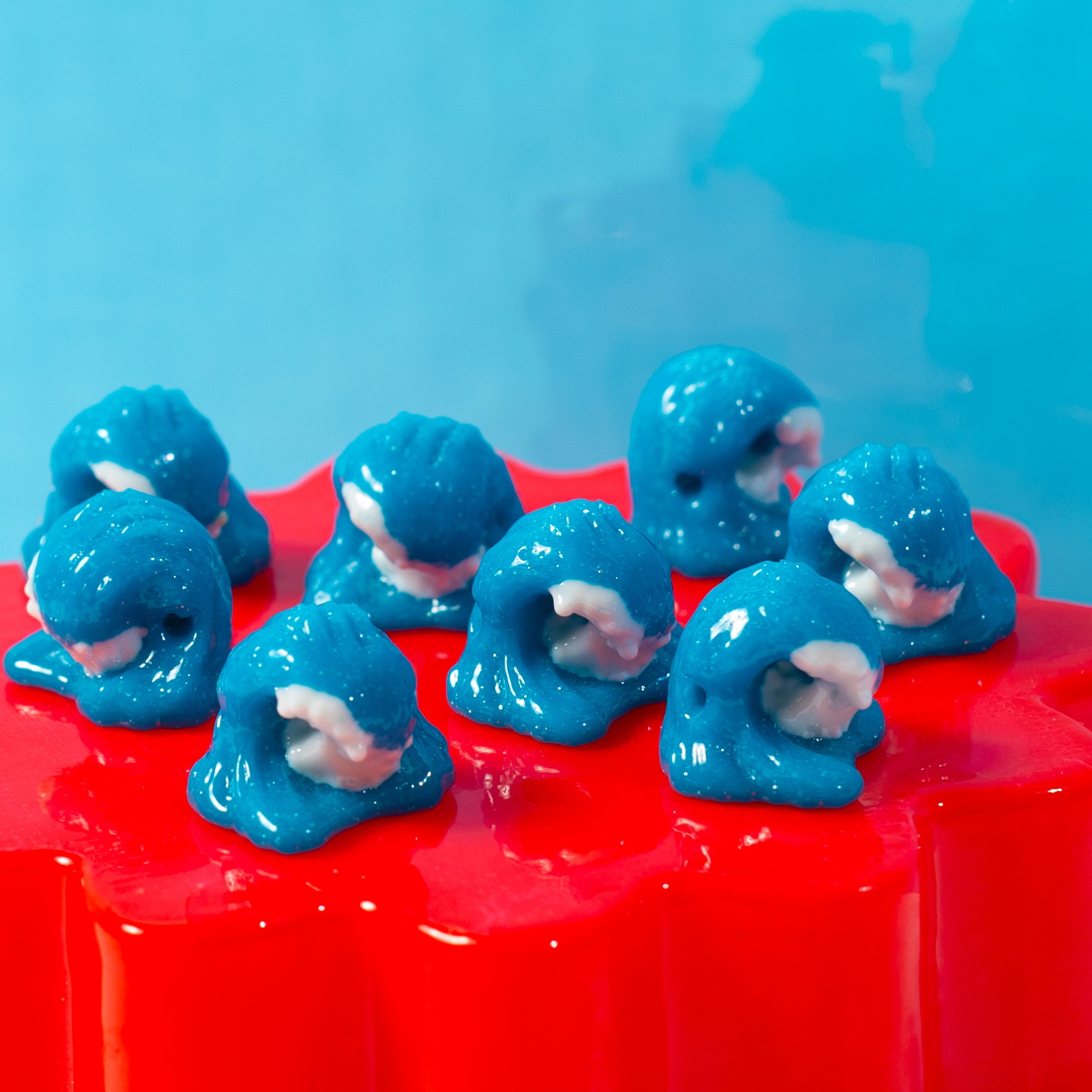 Curling blue wave kandi beads on a red riser against a bright blue backdrop