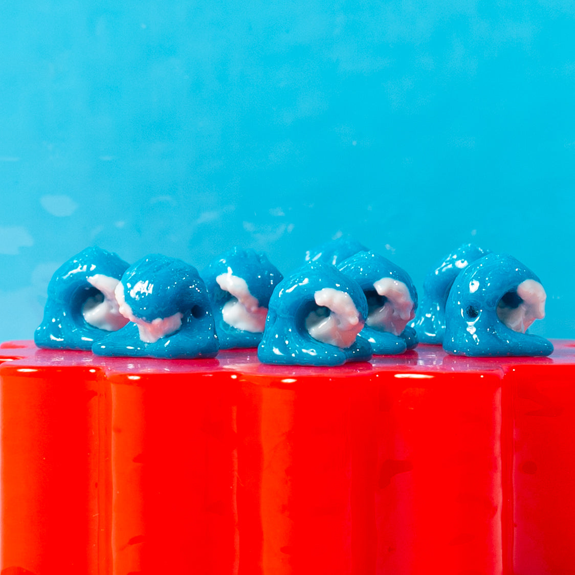 A row of blue wave kandi beads with white foam, drilled holes visible