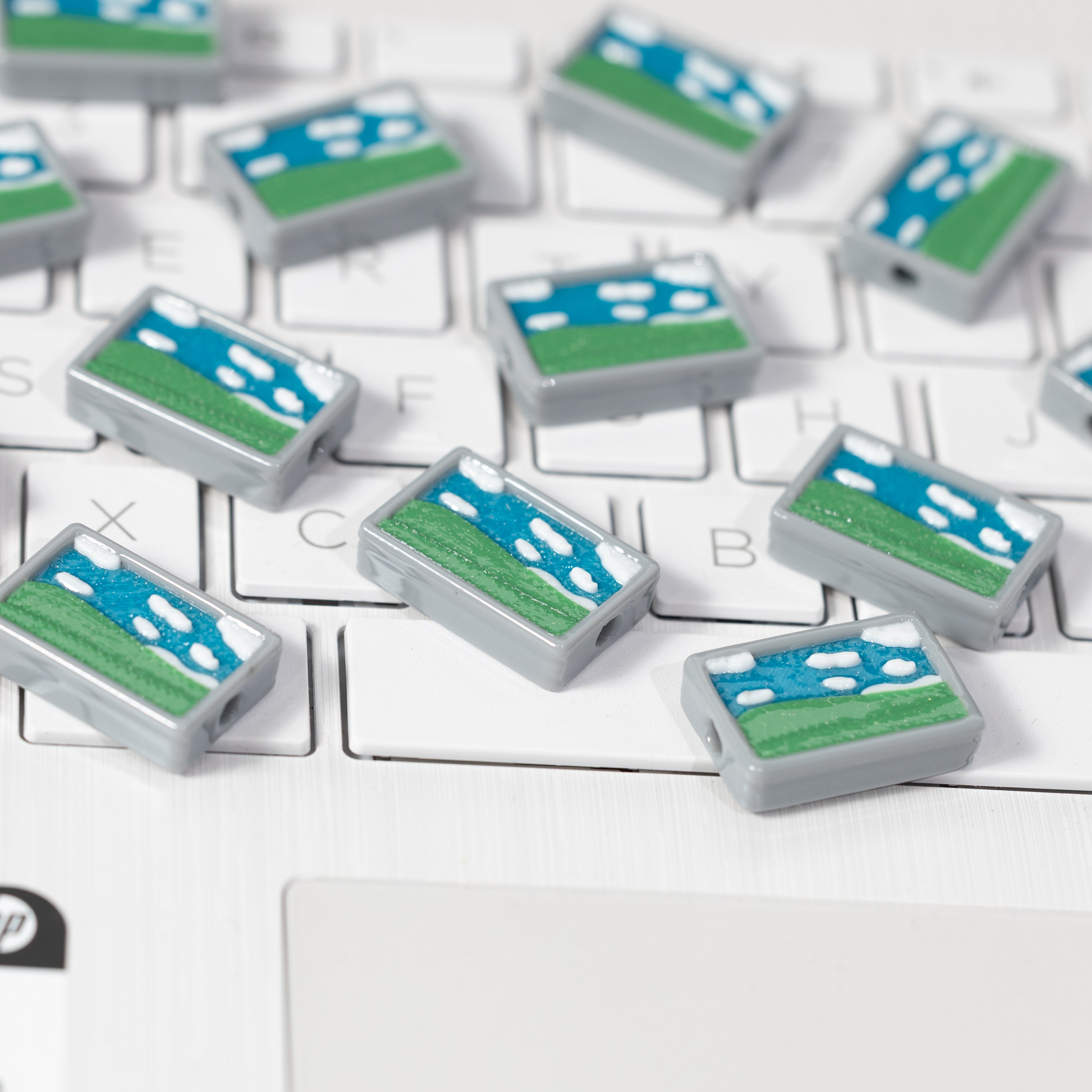 Windows Bliss kandi beads with glittery blue skies and rolling green hills on a keyboard